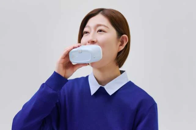 Mulher japonesa usando o g.eN, o primeiro robô de higiene bucal do mundo.