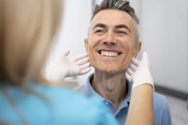Homem sorrindo e confortável com seu implante dentário.
