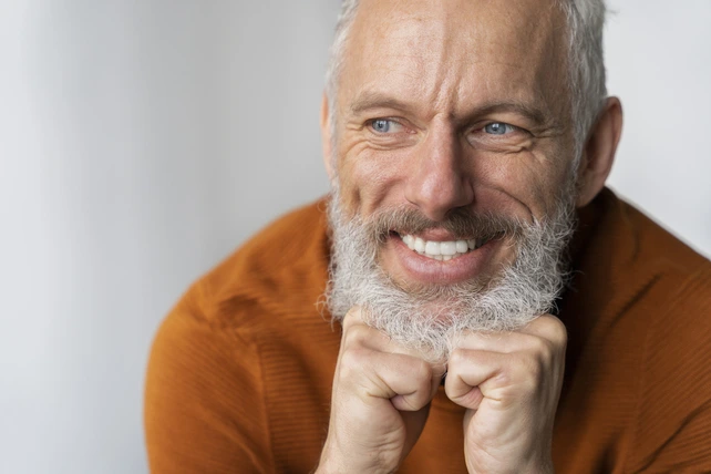 Homem mais velho sorrindo com seu implante dentário.