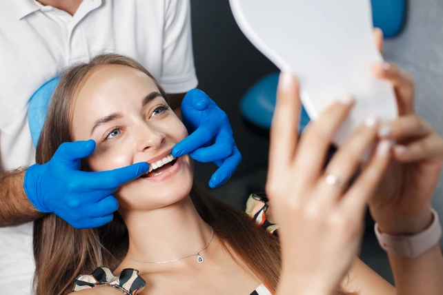 Mulher fazendo clareamento dental no dentista.