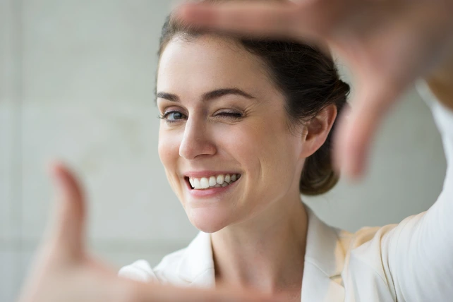Mulher sorrindo após realizar um tratamento de estética dental.